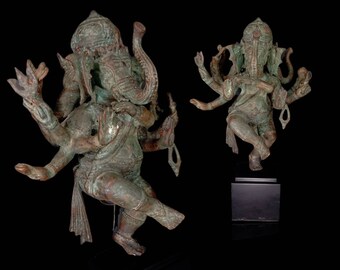 Op de afbeelding: Twee groene bronzen beelden van de hindoe-god Ganesha. De beelden staan ​​beide in een danspose met meerdere armen. Eén beeld staat op een zwarte basis.