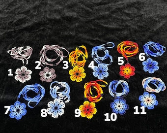 May include: Eleven beaded flower charms in various colors, including blue, purple, orange, and yellow, with numbers 1 through 11 printed below each charm.