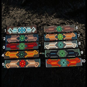 May include: Ten colorful beaded bracelets with geometric patterns. The bracelets are numbered 1 through 10.