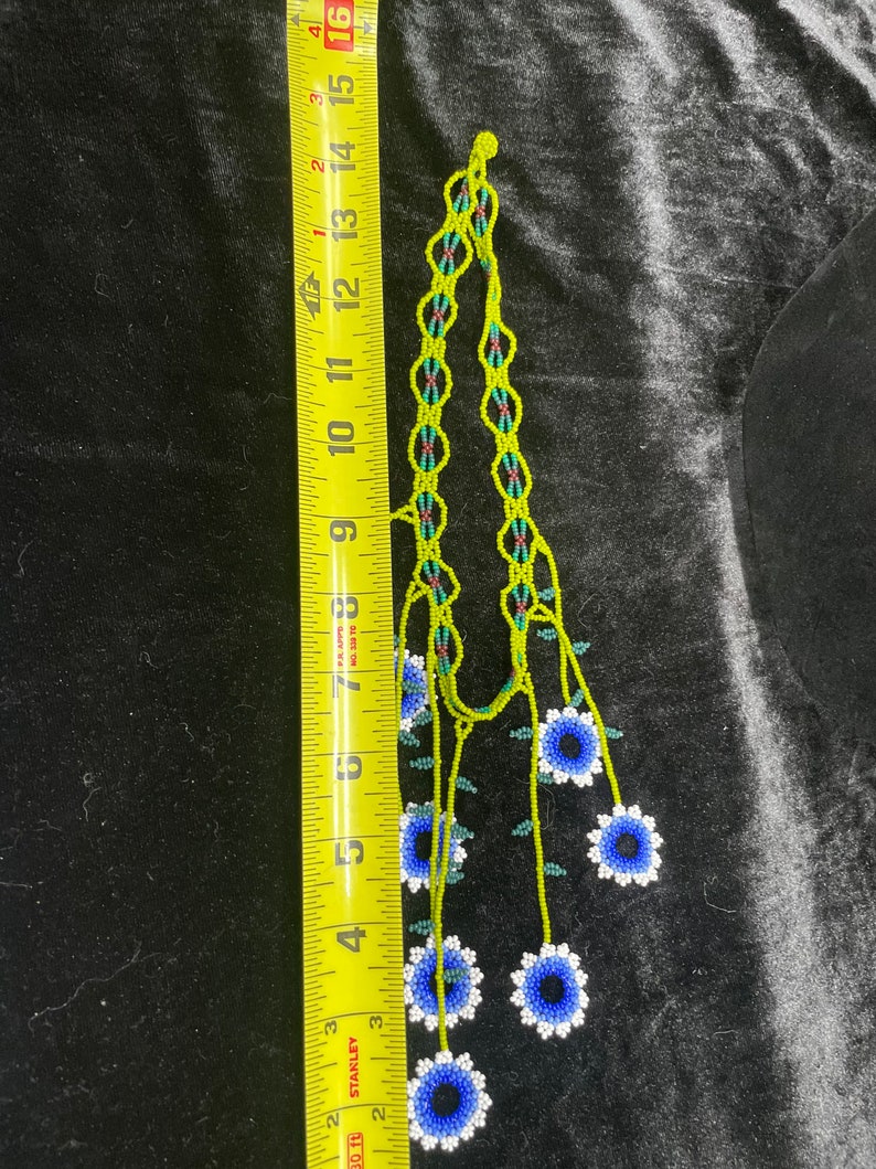 May include: A beaded necklace with a green and blue floral design. The necklace is approximately 15 inches long and features a series of blue and white flowers.