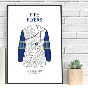 May include: A framed print featuring a stylized illustration of a hockey jersey. The jersey design incorporates a map, with blue sleeves and a yellow and blue plaid pattern. The text "FIFE FLYERS" and "FIFE ICE ARENA" are displayed.