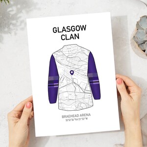 May include: A white print featuring a map design in the shape of a jersey, with purple sleeves and accents. The text "GLASGOW CLAN" is at the top, and "BRAEHEAD ARENA" with coordinates are at the bottom.