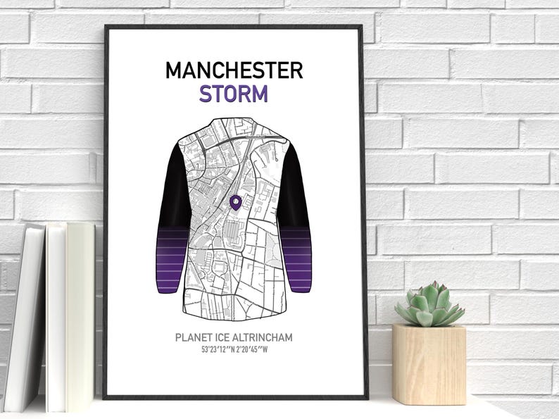 May include: A framed print featuring a map design in the shape of a jacket, with the text "MANCHESTER STORM" at the top. The jacket design has black sleeves and a purple gradient at the bottom. The text "PLANET ICE ALTRINCHAM" is at the bottom.