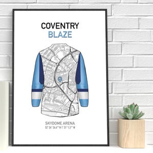 May include: A framed print featuring a stylized map design of a jersey. The jersey design is in white, blue, and navy. The text "COVENTRY BLAZE" is at the top, with "SKYDOME ARENA" and coordinates at the bottom.
