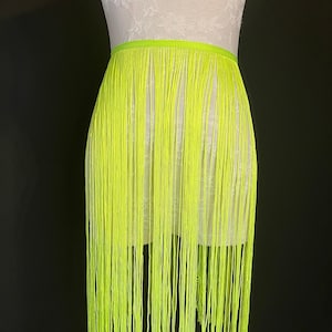May include: A bright neon yellow fringe trim with a straight edge. The fringe is about 3 inches long.