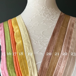Peut inclure: Dix rubans élastiques de différentes couleurs, allant du rose au blanc, sont présentés sur un mannequin blanc. Le ruban est numéroté de 15 à 25.