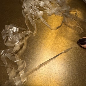 May include: A pile of clear elastic bands on a gold surface.