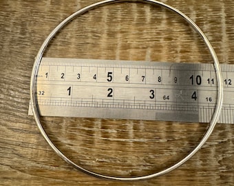 May include: A silver bangle bracelet measuring 10 inches in diameter.