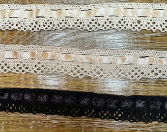 Könnte beinhalten: Drei verschiedene Arten von Spitzenborten, eine in Schwarz und zwei in Creme. Die cremefarbene Spitzenborte hat ein gewebtes Banddesign.