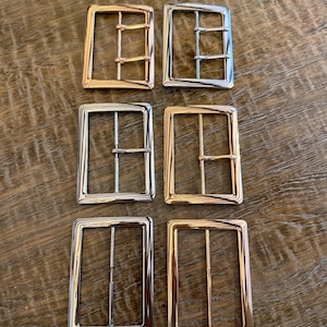 Peut inclure: Six boucles de ceinture rectangulaires en métal disposées en deux colonnes. Les deux du haut ont des doubles ardillons, tandis que les paires du milieu et du bas ont des ardillons simples. Finitions en métal argenté, doré et or rose.