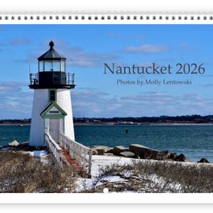 May include: A calendar featuring a white lighthouse with a black top and green trim, set against a blue sky and ocean. The text "Nantucket 2026" and "Photos by Molly Lentowski" are visible.