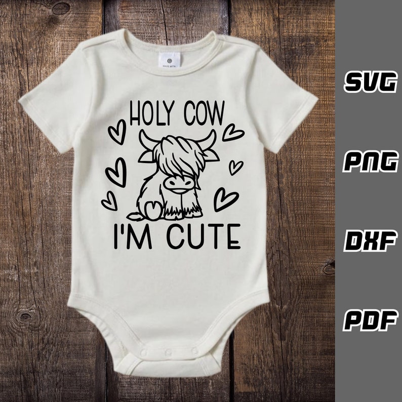 May include: White baby onesie with a black outline of a Highland cow and the text "HOLY COW I'M CUTE" with hearts around the cow.