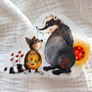May include: A watercolor illustration of a badger and a raccoon. The badger is sitting on its haunches and the raccoon is standing with a jar of honey in its paws. The raccoon is looking at the badger and the badger is looking at the viewer. The background is a light yellow color.