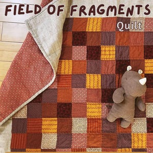 May include: A patchwork quilt featuring a grid of squares in shades of rust, brown, yellow, and cream, with a folded corner revealing a red floral lining. A small brown plush rhinoceros sits on the quilt. Text reads: The FIELD OF FRAGMENTS Quilt. BEGINNER FRIENDLY INSTANT PDF DOWNLOAD PATTERN.