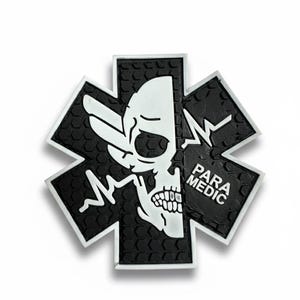 K&ouml;nnte beinhalten: Schwarz-wei&szlig;es Emblem mit einem Totenkopf-Design in einem Lebensstern-Symbol. Der Text "PARA MEDIC" ist sichtbar. Das Emblem hat einen strukturierten Hintergrund und einen wei&szlig;en Rand, oft mit Notfalldiensten verbunden.