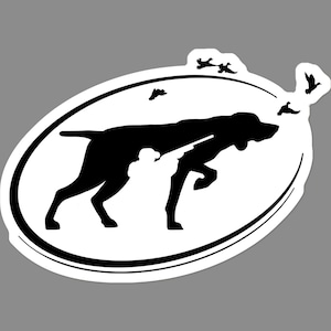 May include: A black and white sticker featuring a silhouette of a hunting dog with a gun, pointing at flying birds. The dog is inside an oval frame with a double black border. The sticker has a white background.