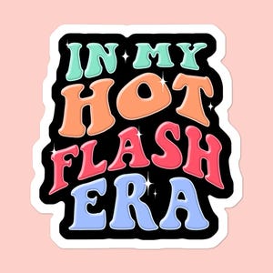 May include: A sticker with the text "IN MY HOT FLASH ERA" in a retro font. The words are in shades of blue, orange, pink, and green, outlined in black with white borders. The background is a light pink.