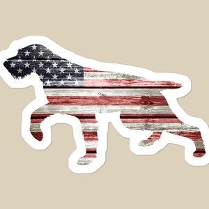 May include: A silhouette of a dog in the shape of the American flag. The flag is made of wood planks with a distressed look. The dog is standing on its hind legs with its front paws raised.