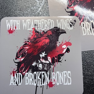 May include: A gray sticker with a red crow with black wings and the text "WITH WEATHERED WINGS AND BROKEN BONES".