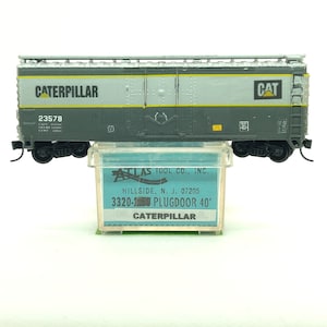 Custom painted and decaled N-scale Atlas boxcar, grey with Caterpillar logo