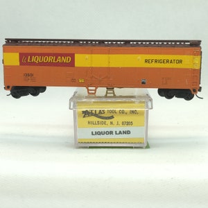 Custom painted and decaled N-scale Atlas boxcar, orange and brown with Liquorland logo