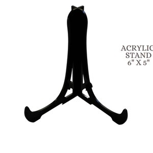 May include: Black acrylic display stand for artwork or photos. The stand is 6 inches by 5 inches.