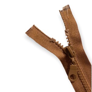 May include: A brown zipper with a plastic slider. The zipper is open and the slider is in the middle of the zipper.