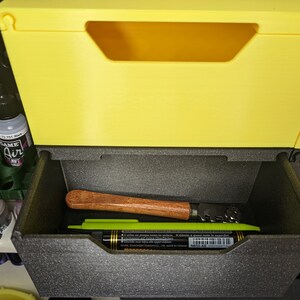 May include: A yellow plastic storage bin with a black foam insert. The insert has a wooden tool and a green marker inside.