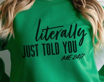 May include: A bright green sweatshirt with the text "literally just told you me 24/7" in black script. The long-sleeved top is made of a soft material and is suitable for casual wear.