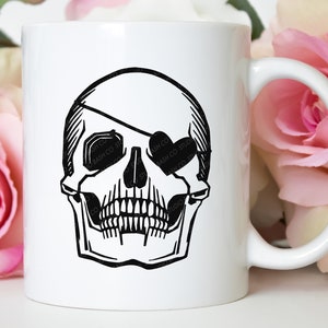 Könnte beinhalten: Weiße Keramiktasse mit einer schwarz-weißen Illustration eines Schädels mit Augenklappe. Der Schädel ist im Vintage-Stil gehalten.