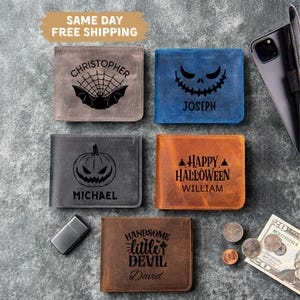 May include: A collection of personalized leather wallets in various colors, each featuring a unique Halloween-themed design. The wallets include a bat and spiderweb, a jack-o'-lantern face, and the text "Happy Halloween".