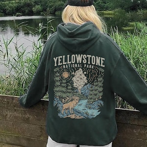 May include: A forest green hoodie with a graphic print of a mountain scene and the text "Yellowstone National Park".