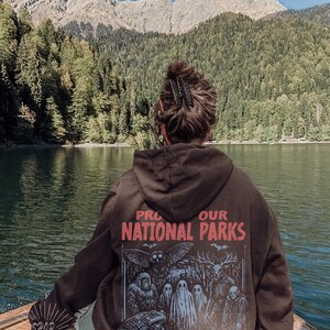 Sudadera con capucha vintage de parques nacionales de críptidos UNSX de los 90, sudadera para proteger nuestros parques, camping y senderismo, camiseta retro Wanderlust, sudadera con capucha de criaturas fantásticas Dark Chocolate