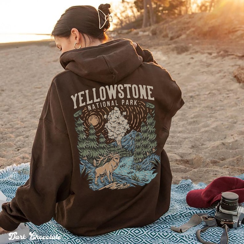 May include: A brown hoodie with a graphic print of a forest scene and the text "Yellowstone National Park".