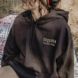 May include: A black hooded sweatshirt with the text "Sequoia National Park" printed on the front.