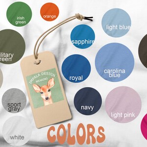 May include: A chart of fabric swatches with color names, including forest green, irish green, orange, sand, military green, sport gray, ash, white, gold, light blue, sapphire, dark chocolate, carolina blue, royal, navy, light pink, maroon, and heliconia. The chart also includes a small image of a deer with the text "IMPALA DESIGN WEARING".