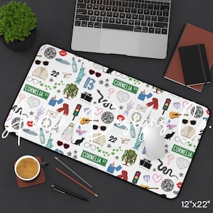 May include: White mouse pad with a repeating pattern of sunglasses, hearts, and other icons. The pad measures 12" x 22". Includes the text "Cornelia St" and the number "22".