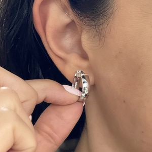 These super-chic and shiny 14k white gold flat, slightly chunky and wide hoops feature a domed tubular shape. These fine quality ITALIAN gold small/medium hoop earrings keep secure with click-top posts. Hollow lightweight classic white gold hoops.