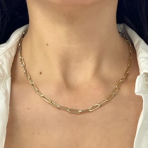 May include: A gold chain necklace with a simple, linked design. The chain is made of oval-shaped links.