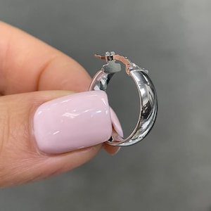 These super-chic and shiny 14k white gold flat, slightly chunky and wide hoops feature a domed tubular shape. These fine quality ITALIAN gold small/medium hoop earrings keep secure with click-top posts. Hollow lightweight classic white gold hoops.