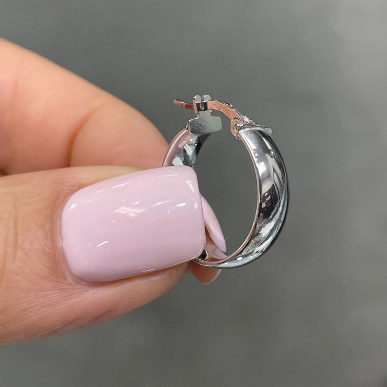These super-chic and shiny 14k white gold flat, slightly chunky and wide hoops feature a domed tubular shape. These fine quality ITALIAN gold small/medium hoop earrings keep secure with click-top posts. Hollow lightweight classic white gold hoops.