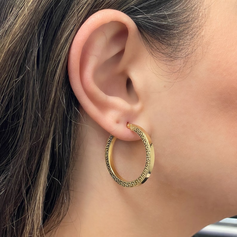 Stylish and stunning 14k yellow gold round hoops featuring a textured appearance and square tubular shape. These shiny ITALIAN gold hollow tubular earrings are lightweight and secure. Greek Key pattern Meandros trimmed square tubular hoop earrings.