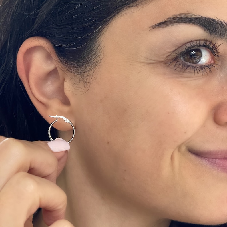 These super-chic and shiny 14k white gold flat, slightly chunky and wide hoops feature a domed tubular shape. These fine quality ITALIAN gold small/medium hoop earrings keep secure with click-top posts. Hollow lightweight classic white gold hoops.