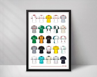 May include: A framed poster displaying a grid of twenty-five illustrated soccer jerseys in various colors and designs, including white, yellow, green, black, and grey. The bottom of the print features a horizontal red line and the text EST. 1892.