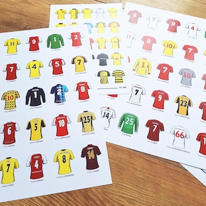 May include: A set of 10 printed sheets featuring different football shirts with player names and numbers. The shirts are in various colours, including red, yellow, and blue. The sheets are printed on white paper.