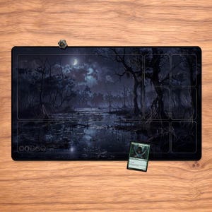 May include: A black rectangular playmat featuring a swamp scene with a full moon, trees, and water. A small die and a Magic: The Gathering card are on the mat. The mat has designated areas for gameplay.