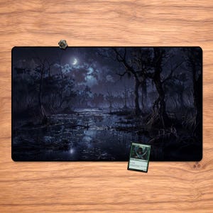 May include: A rectangular playmat featuring a dark, swampy landscape under a moonlit sky. The artwork depicts gnarled trees, still water, and a crescent moon. A small, green trading card and a dice are on the mat.
