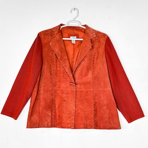 Peut inclure: Un blazer en daim orange brûlé doté de manches longues, d'un col à revers cranté et d'une fermeture à un seul bouton. Les panneaux avant sont ornés de détails verticaux en point de surjet le long des coutures, avec une doublure intérieure.