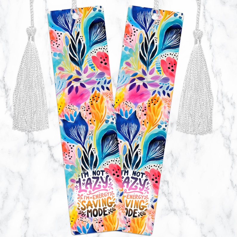 May include: Two colorful floral bookmarks with white tassels. The bookmarks feature the text "I'm not lazy, I'm energy saving mode".