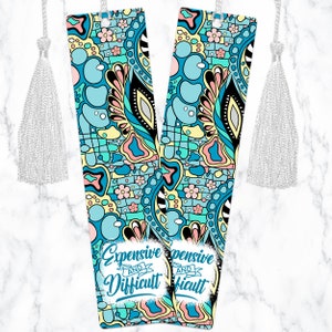 May include: Two colorful bookmarks with a blue, yellow, pink, and green abstract pattern. The bookmarks have a white tassel and the text "Expensive and Difficult" on them.